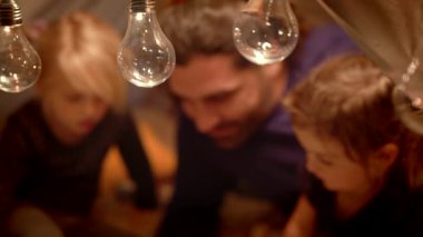 Baba ve kızları akşam wigwam bir kitap okuyor