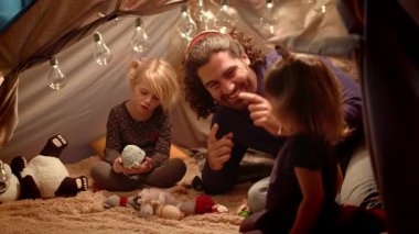 Babam ve kızları evde çadırda. Babam bir balığı taklit eder..