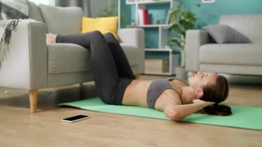 Oturma odasında abs egzersizleri yapan kadın