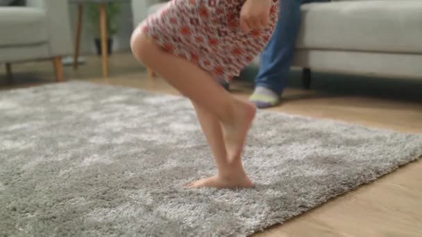 Mała dziewczynka tańczy z tatą i siostrą w domu — Wideo stockowe