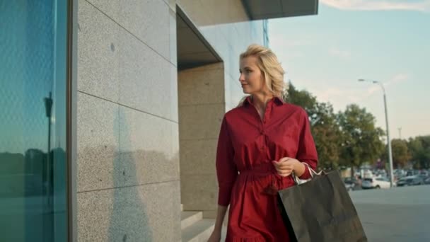 Μια γυναίκα λατρεύει τα ψώνια, περπατάει κοντά στο παράθυρο — Αρχείο Βίντεο