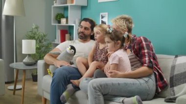 Mutlu aile kanepede oturan evde çizgi film izlemek