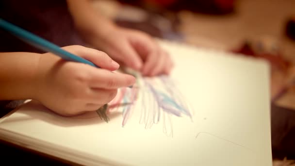 Крупный план Маленькая девочка рисует карандашами в декоративной палатке — стоковое видео