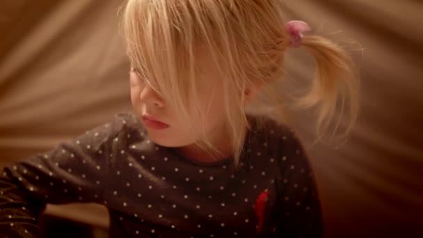 Маленька дівчинка малює олівцями в декоративному наметі у вітальні вночі — стокове відео