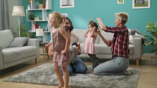 Vader en moeder spelen met dochters met plezier dansen thuis — Stockvideo