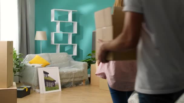 Mladí manželé přinášejí krabice do nového bytu a Mazli — Stock video