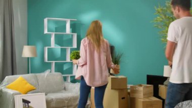 Genç çift yeni bir eve kutuları getiriyor ve yüksek bir beş verir