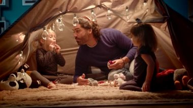 Babam ve kızları evde çadırda. Babam bir baykuşu taklit eder..