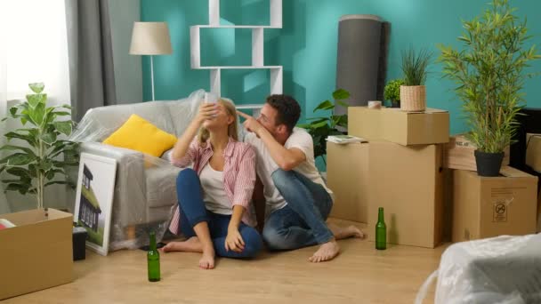 Νεαρό ζευγάρι κάνει μια βιντεοκλήση σε ένα smartphone σε ένα νέο σπίτι — Αρχείο Βίντεο