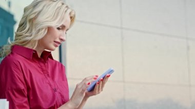 Kırmızı elbiseli genç güzel kız akıllı telefonu kullanıyor