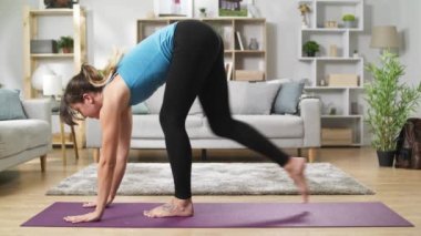 Çekici kadın yoga güneşli rahat oturma odasında sabah köpek pozlar yok