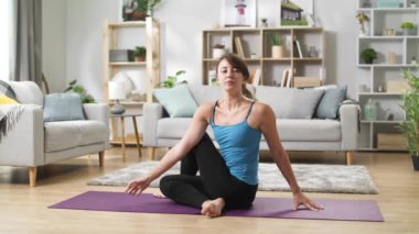 Pretty yoga kadın bacaklar uzanır, virajlar ve evde uzanır