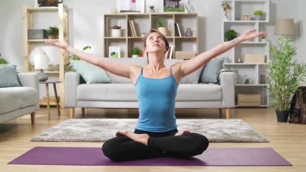 Yogi-Frau sitzt auf dem Boden im Wohnzimmer in Lotus mit Fingern in Mudra — Stockvideo