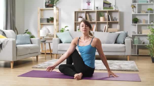 Mujer bonita yoga estira las piernas, se dobla y se estira en casa — Vídeos de Stock