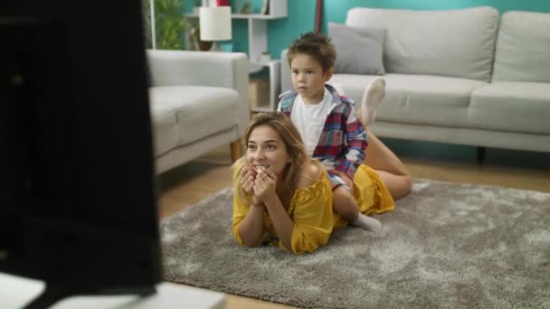 Moeder en zoon kijken tv, zoon zit op Moms terug — Stockvideo