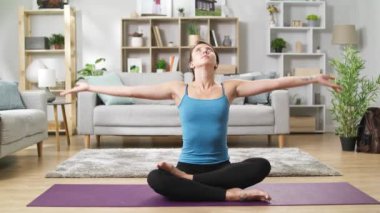 Yogi kadın oturma odasında katta oturan ve mudra parmakları bağlamak