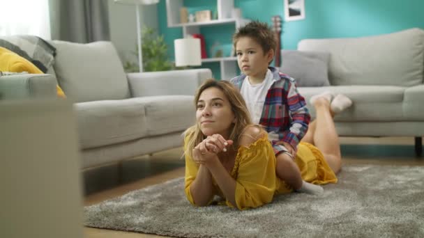 Mamma och Lille pojke tittar på TV, son sitter på mammor tillbaka — Stockvideo