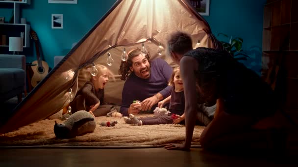 Maman, papa et deux filles jouent un monstre le soir dans une tente de jouets — Video