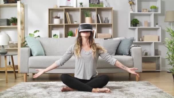Kvinna hemma gör Namaste i Lotus pose med Virtual Reality headset — Stockvideo