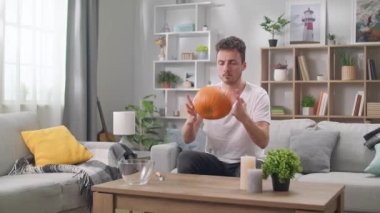 Genç bir adam bir balkabağı alır ve Jack 'in fenerini oymaya başlar.