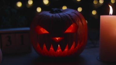 Ahşap masa üzerinde mumları olan Cadılar Bayramı balkabakları.