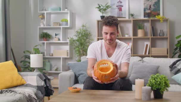 Mladý muž zkoumá Jacks lucerna připravena ve svém obývacím pokoji — Stock video