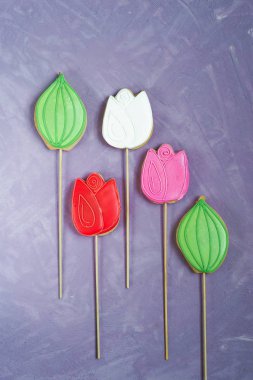 leylak arka planda lale şeklinde bir sopa üzerinde zencefilli çörek. Ev yapımı tatil hamur işleri