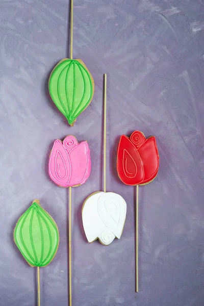 Gingerbread on a stick in the form of tulips on a lilac background. Homemade holiday pastries — Stock Photo, Image