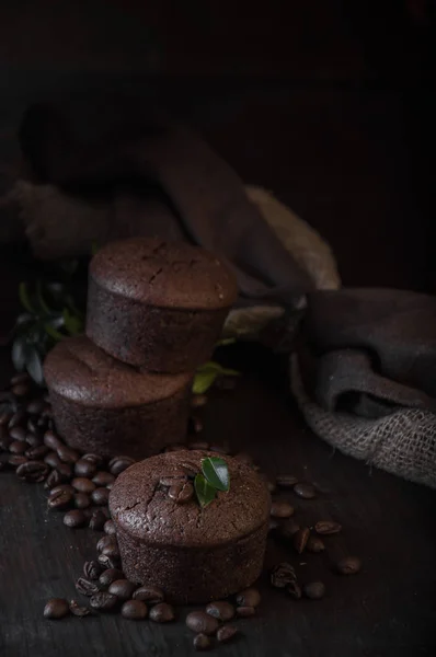 Schokoladen- und Kaffeemuffins auf dunklem Holzgrund — Stockfoto