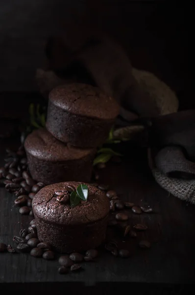 Schokoladen- und Kaffeemuffins auf dunklem Holzgrund — Stockfoto