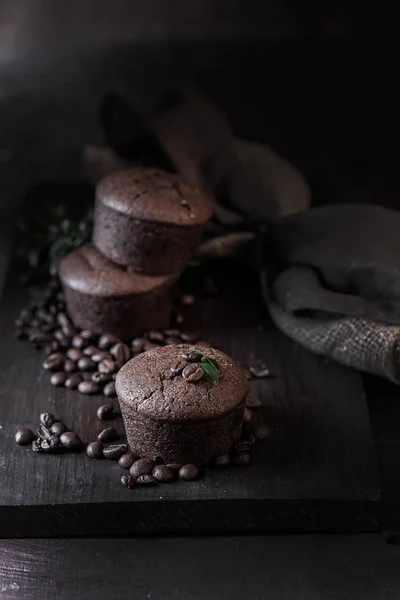 Шоколадные и кофе кексы на темном деревянном фоне — стоковое фото
