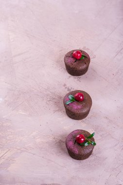 bej bir arka plan üzerinde üstüne bir kiraz ile çikolata cupcakes