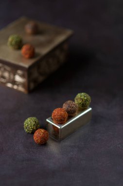 çikolata yuvarlak şekerler koyu bir arka plan üzerinde baharat serpilir