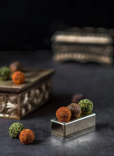 Шоколадные конфеты, посыпанные специями на темном фоне — стоковое фото