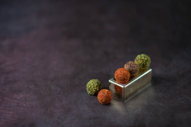 çikolata yuvarlak şekerler koyu bir arka plan üzerinde baharat serpilir