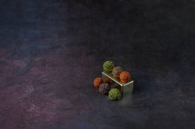 çikolata yuvarlak şekerler koyu bir arka plan üzerinde baharat serpilir