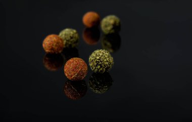çikolata yuvarlak şekerler koyu bir arka plan üzerinde baharat serpilir