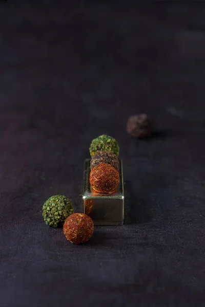 Шоколадные конфеты, посыпанные специями на темном фоне — стоковое фото