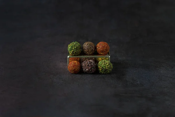 Chocolade ronde snoepjes bespkeld met specerijen op een donkere achtergrond — Stockfoto