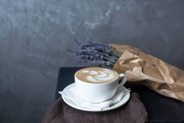 Filiżankę cappuccino na brązowej serwetce z lawendy — Zdjęcie stockowe