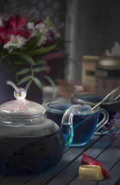 Cam bardak ve çaydanlık Tay mavi çay. Çiçekler ve şekerler.