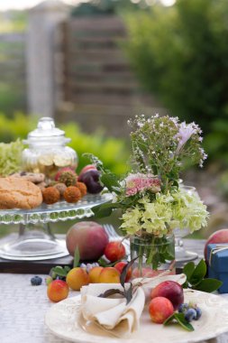 Yaz bahçesinde şenlikli tedavi ve beyaz masa örtüsü ile Tablo