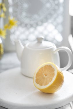 Taze limon ve beyaz çaydanlık yarısı gri arka plan üzerinde