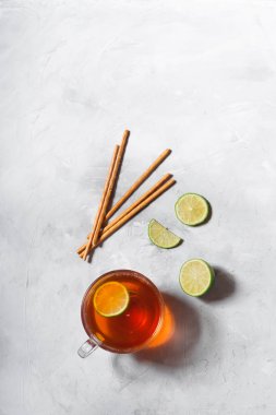 Limon dilimleri ile cam kupa siyah çay. Gri arka planda