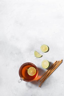 Limon dilimleri ile cam kupa siyah çay. Gri arka planda