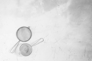 Gri beton arka plan üzerinde metal elek. Renkli bir fotoğraf değil.