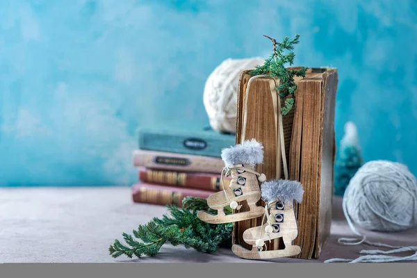 Yeni yıl ve Noel kompozisyonu. Eski bir kitap, paten şeklinde ahşap bir oyuncak. Ve bir iğne parçası..