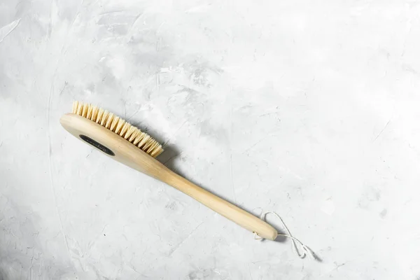 Wooden brush for dry massage lies on a gray background. View from above — Stock Photo, Image