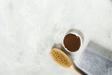 Kuru masaj için ahşap fırça ve havlu ile öğütülmüş kahve. Yukarıdan görüntüle