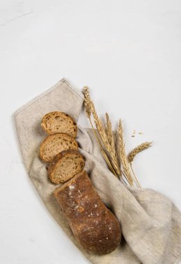 çavdar unundan yapılmış koyu ekmek bir somun dilimler halinde kesilmiş beyaz bir arka plan üzerinde yatıyor.